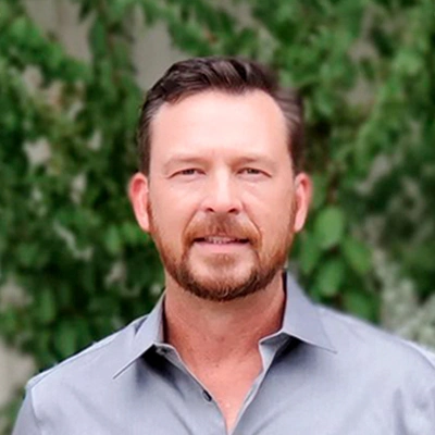 Dr. Jason Trowbridge protrait photo wearing a grey shirt with green background.
